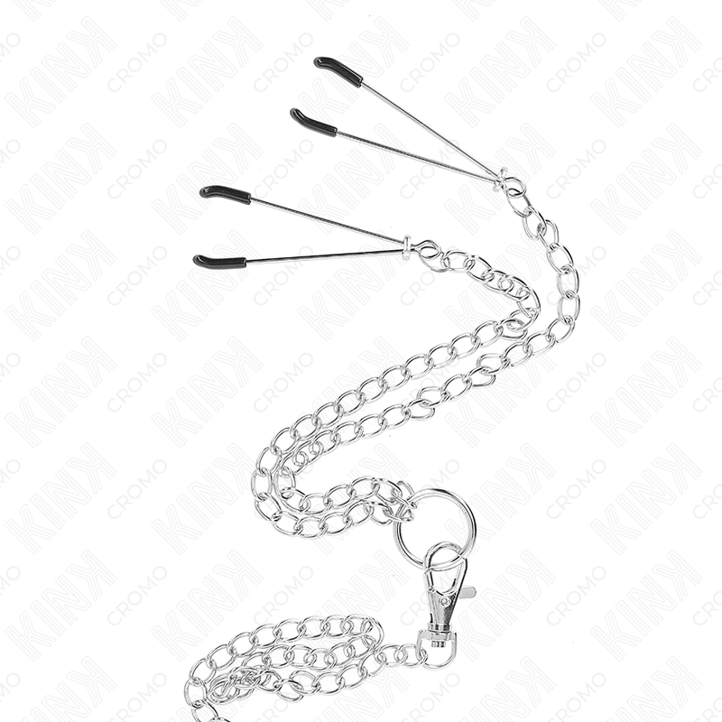 Anello per pene KINK in metallo cromato, catena di 26 cm e morsettini per capezzoli, in dettaglio.